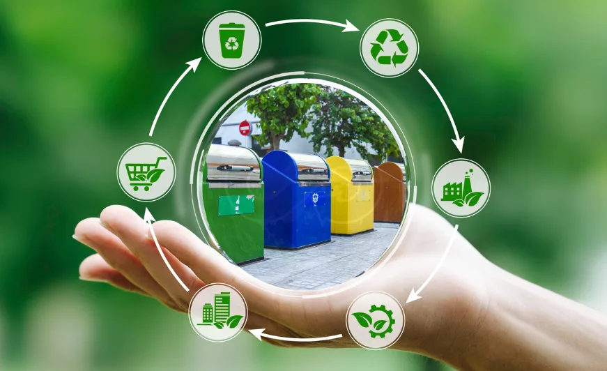 Una mano sosteniendo iconos de economía circular alrededor de coloridos contenedores de reciclaje en Barcelona.
